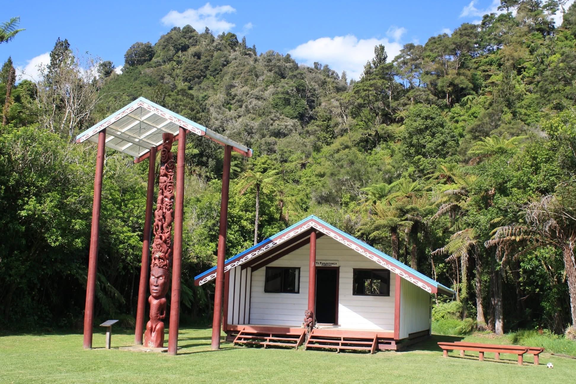 The pou whenua and Te Puawaitanga o Hinekura wharenui at Tieke