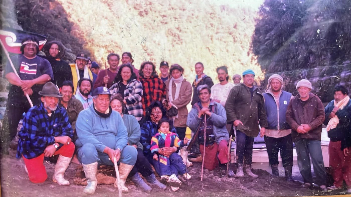 Whānau on the riverbank at Tieke with the tino rangatiratanga flag