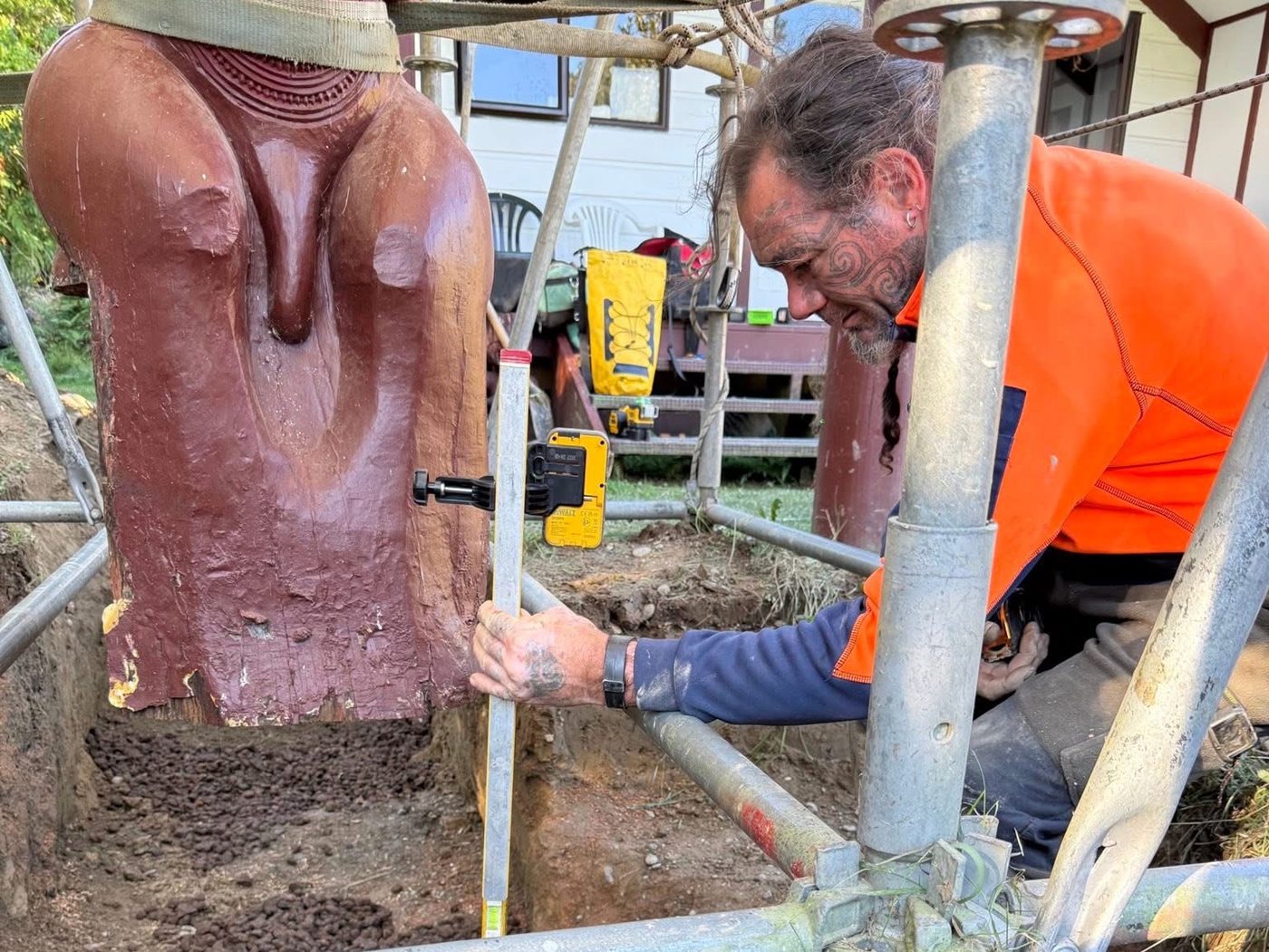 Levelling the base of the pou whenua during its restoration at Tieke