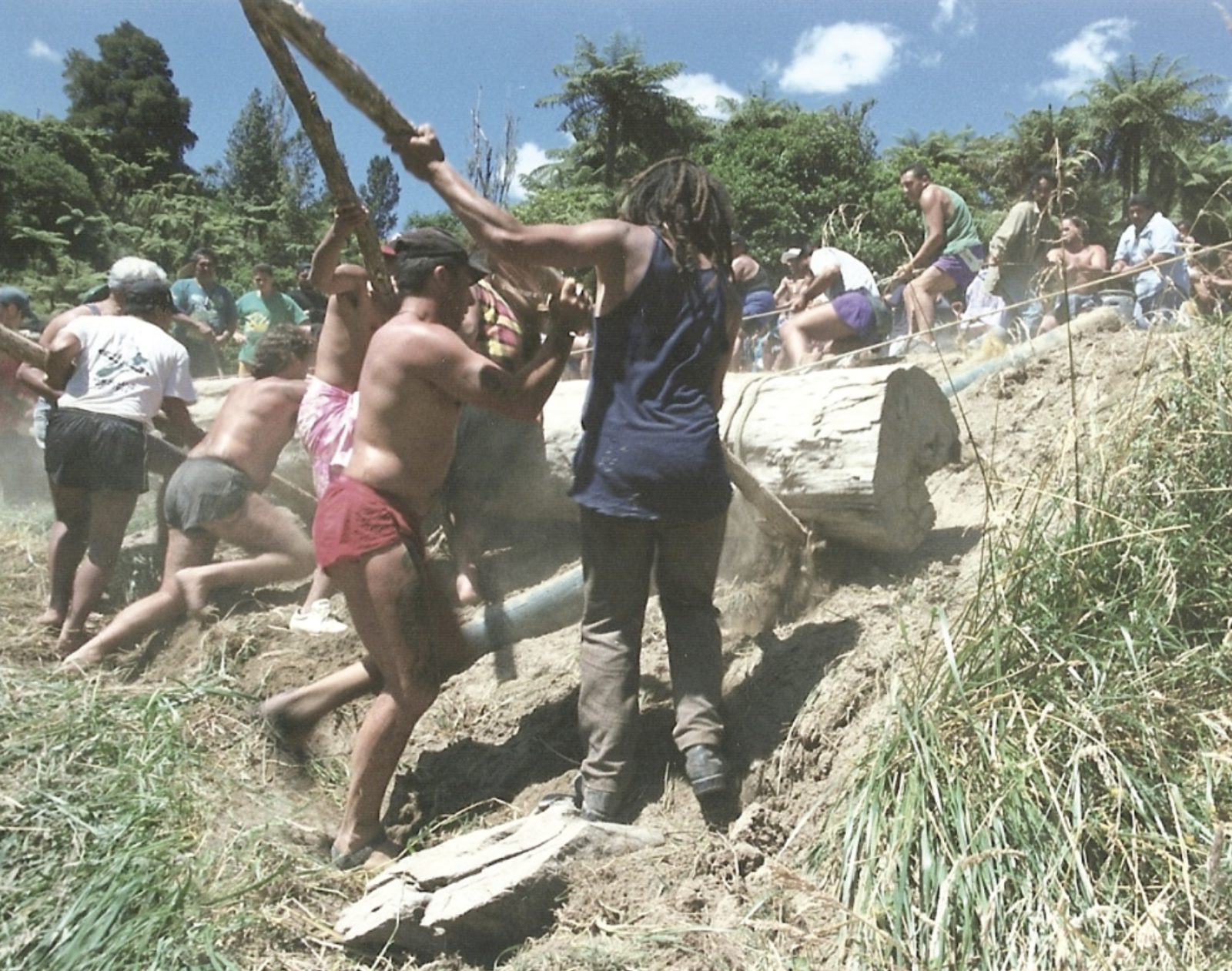 Whānau moving the tōtara log up from the awa for the pou
